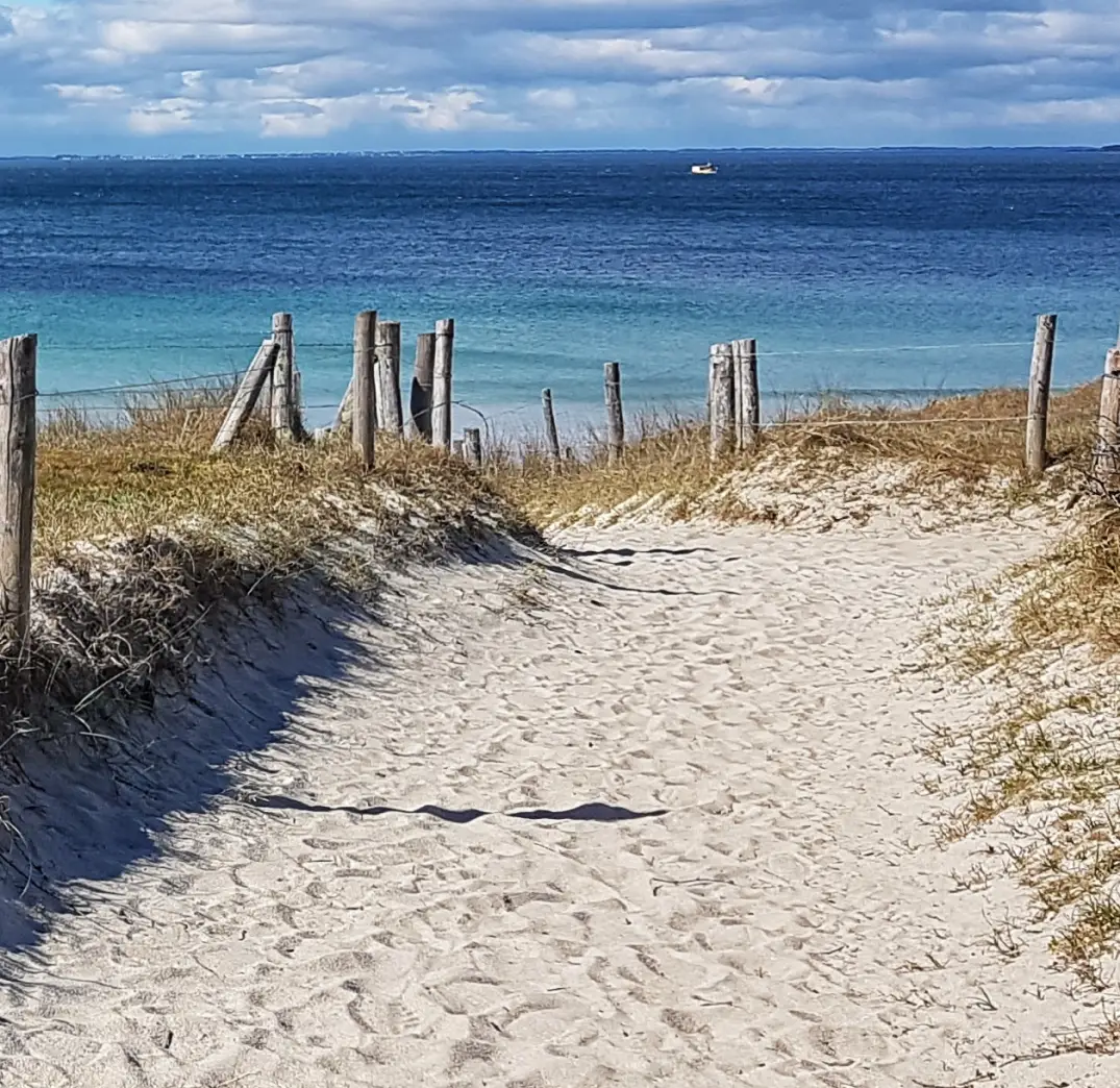 Allée de sable menant à l'océan